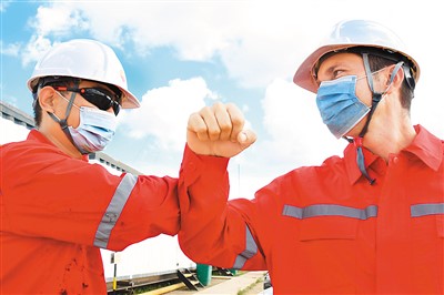 2020年11月27日，中国石油集团长城钻探工程公司古巴项目GW91钻井平台中方员工（左）同古巴员工互相致意。华金·埃尔南德斯摄（新华社发）