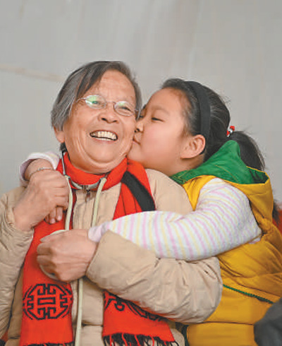 路生梅（左）在义诊时，孩子亲密地拥抱她。新华社记者 陶 明摄
