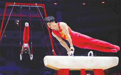 当地时间11月2日，中国队选手杨家兴（前）在利物浦体操世锦赛男团决赛鞍马比赛中。场地不远处，另一名参赛选手在进行吊环比赛。