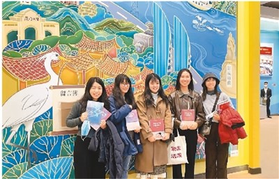 图为台湾青年在展览的“两岸一家亲”彩绘墙前合影留念。
