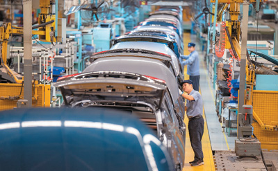 10月11日，海南省海口市某汽车基地的生产车间内，工作人员在新能源车生产线上作业。袁 琛摄（人民视觉）
