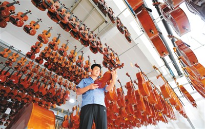 河北省肅寧縣一家樂器生產企業的工人在成品車間檢查樂器質量。新華社記者 朱旭東攝