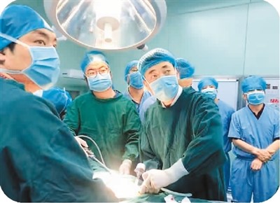 图为马文义（右一着绿色手术服者）和同事在为患者做手术。
