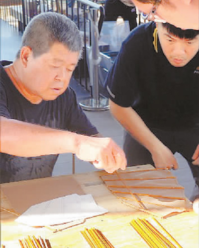 林伟球（左）教授传统造船技艺并分享造船经验。唐 佳摄
