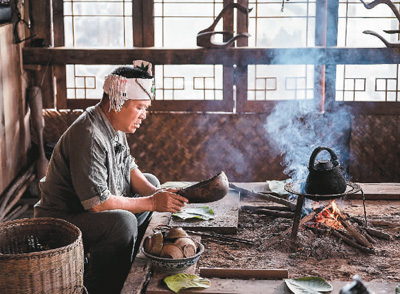 景迈山芒景村的布朗族茶农在火塘边做烤茶。
