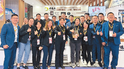 十一月八日，符应（左一）与同事在上海环球食品展的展位前合影。受访者供图
