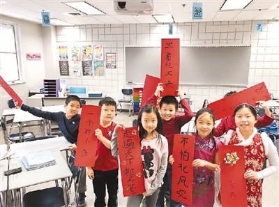 美国俄亥俄州现代中文学校中文班的孩子展示写好的书法习作。