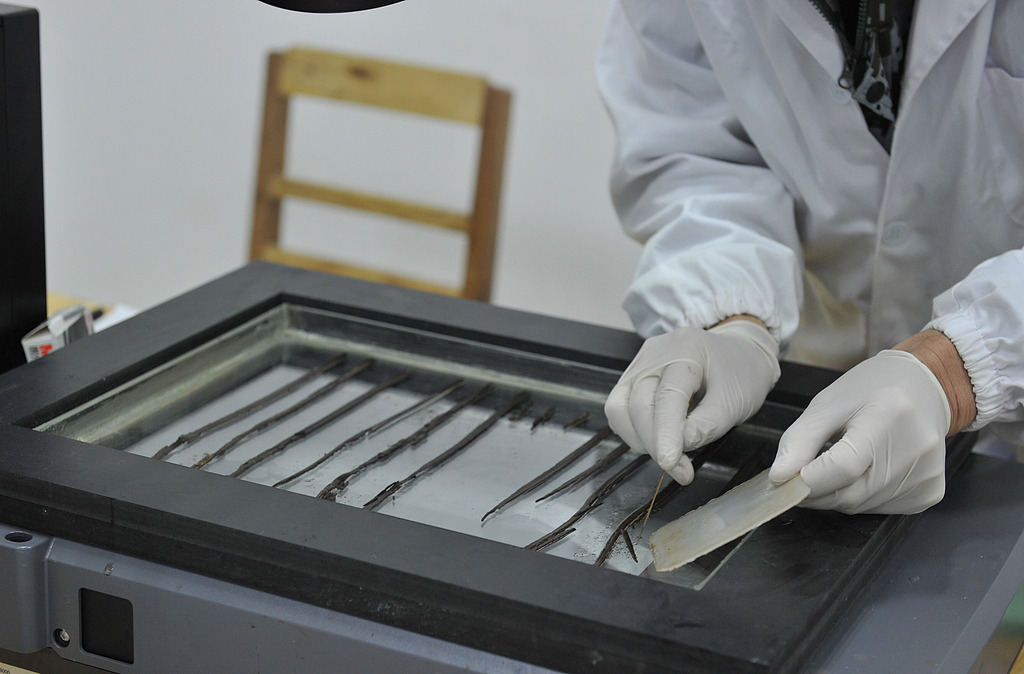 △在海昏侯墓文物保护工作站，工作人员通过红外扫描对竹简上的文字进行辨识。来源：视觉中国